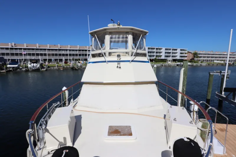 Sea Breeze Yacht Photos Pics 1985 Hatteras 43 Motor Yacht docked at marina, clear blue sky background.