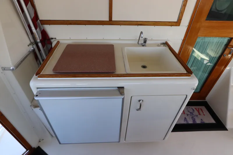 Sea Breeze Yacht Photos Pics Compact kitchen area on a 1985 Hatteras 43 Motor Yacht with sink and storage.