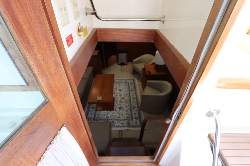 Sea Breeze Yacht Photos Pics Interior view of 1985 Hatteras 43 Motor Yacht, featuring cozy seating and wooden accents.