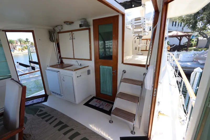 Sea Breeze Yacht Photos Pics Interior view of 1985 Hatteras 43 Motor Yacht with kitchenette and outdoor access.