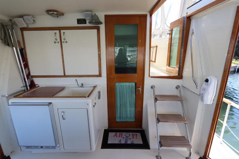 Sea Breeze Yacht Photos Pics 1985 Hatteras 43 Motor Yacht interior with kitchenette, wooden door, and steps.