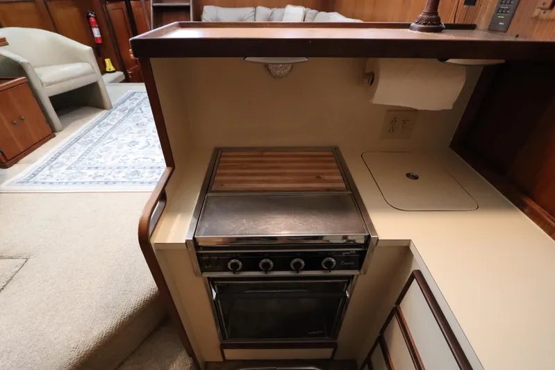 Sea Breeze Yacht Photos Pics 1985 Hatteras 43 Motor Yacht kitchen with stove, sink, and cozy seating area.