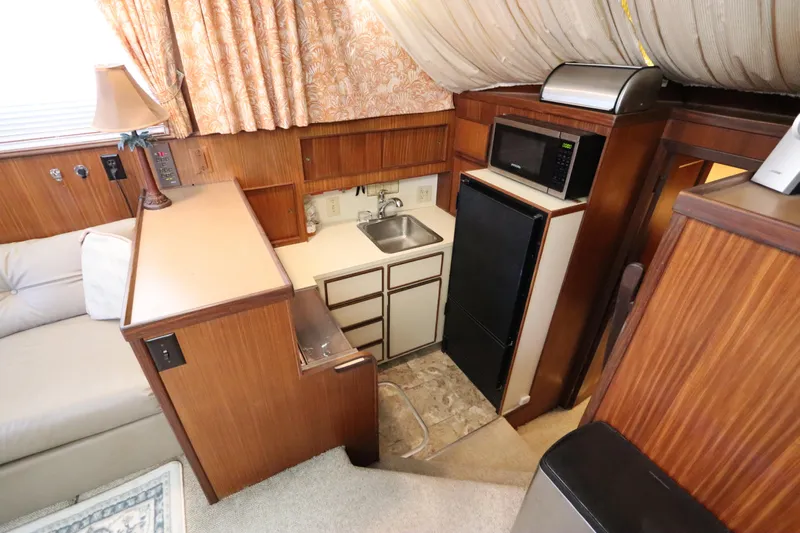 Sea Breeze Yacht Photos Pics Interior of 1985 Hatteras 43 Motor Yacht with compact kitchen and wood paneling.