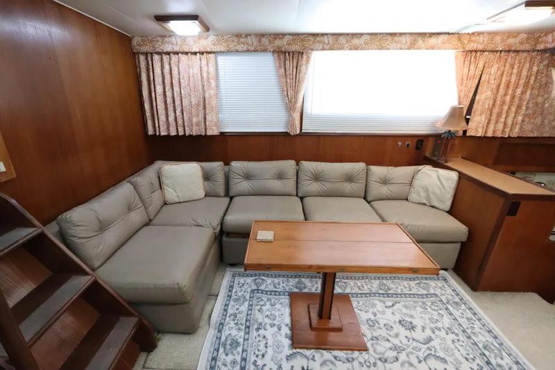 Sea Breeze Yacht Photos Pics Interior of 1985 Hatteras 43 Motor Yacht with cozy seating and wooden table.