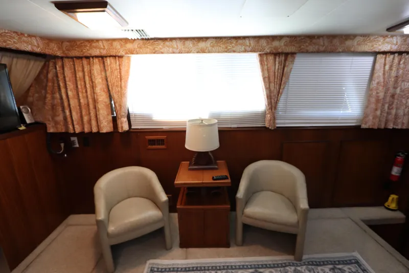 Sea Breeze Yacht Photos Pics Interior of 1985 Hatteras 43 Motor Yacht with chairs, table, and lamp.