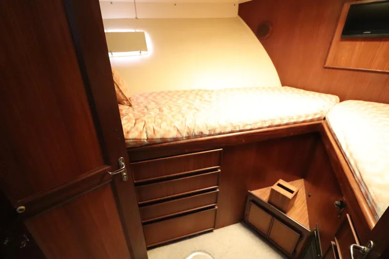 Sea Breeze Yacht Photos Pics 1985 Hatteras 43 Motor Yacht cabin with twin beds and wooden interior.