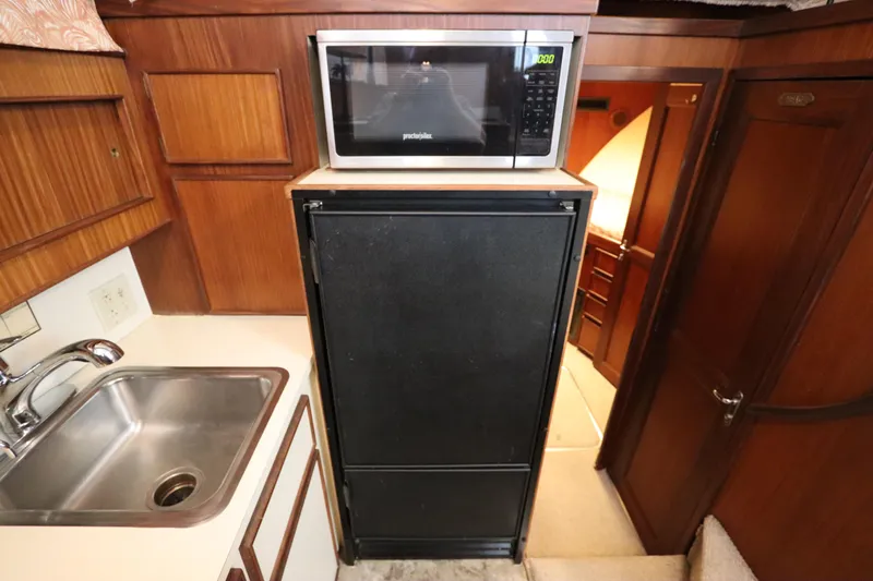 Sea Breeze Yacht Photos Pics 1985 Hatteras 43 Motor Yacht kitchen with sink, microwave, and refrigerator.