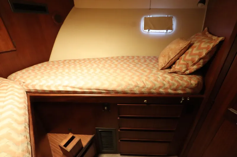 Sea Breeze Yacht Photos Pics 1985 Hatteras 43 Motor Yacht cabin with single bed and wooden storage drawers.