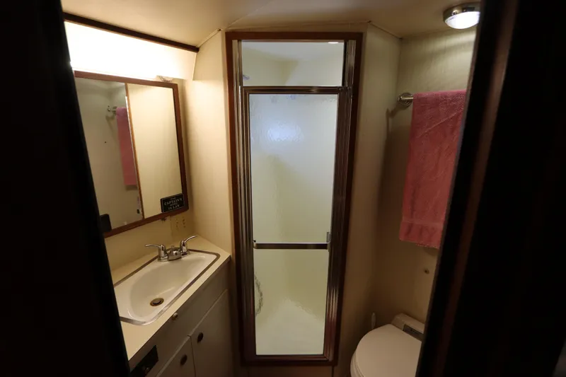Sea Breeze Yacht Photos Pics Bathroom interior of 1985 Hatteras 43 Motor Yacht with shower, sink, and toilet.