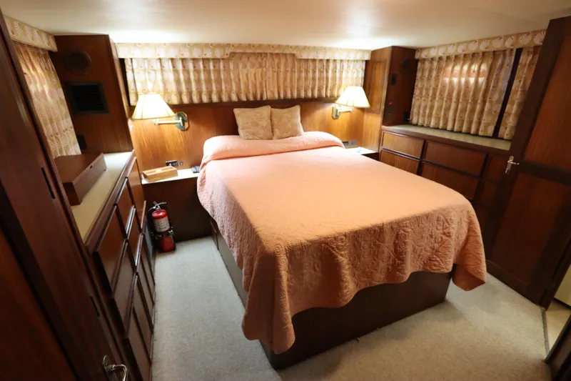 Sea Breeze Yacht Photos Pics 1985 Hatteras 43 Motor Yacht bedroom with cozy decor and soft lighting.