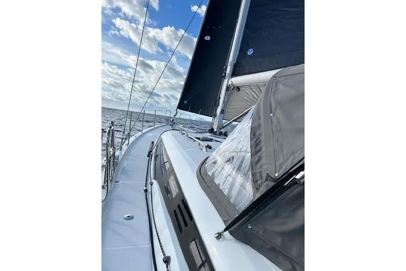 Agua Especial Yacht Photos Pics Sailing on a 2016 Jeanneau 54 yacht with black sails under a blue sky.