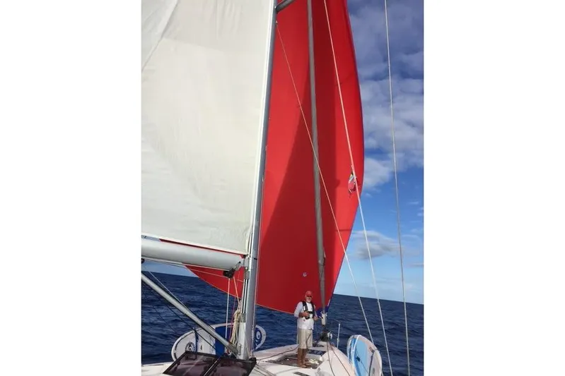 Agua Especial Yacht Photos Pics 2016 Jeanneau 54 sailboat with red sail on open sea under blue sky.