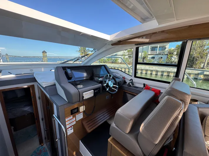 Truly Ineffable Yacht Photos Pics 2019 Cruisers Yachts 42 Cantius helm with modern controls and waterfront view.