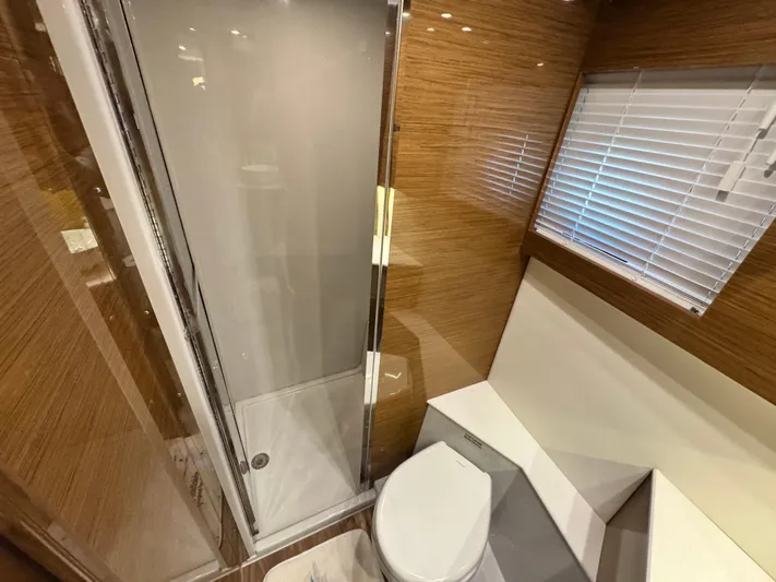 Truly Ineffable Yacht Photos Pics 2019 Cruisers Yachts 42 Cantius bathroom with shower, toilet, and wooden accents.