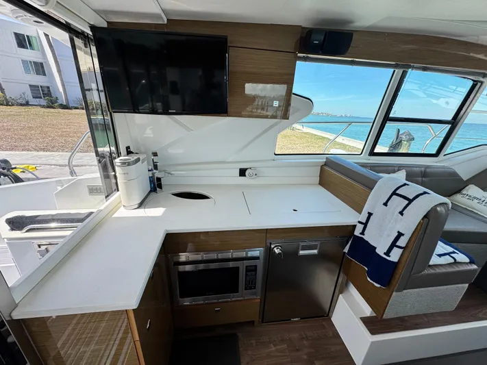 Truly Ineffable Yacht Photos Pics Interior of 2019 Cruisers Yachts 42 Cantius, featuring modern kitchen and scenic window view.