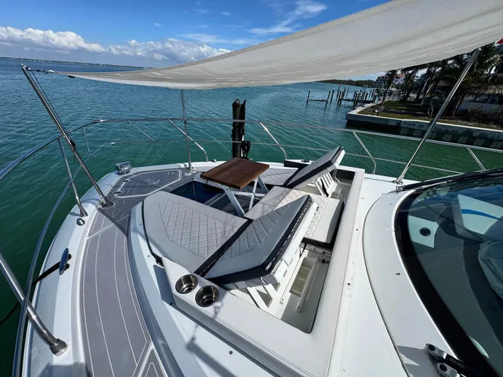 Truly Ineffable Yacht Photos Pics 2019 Cruisers Yachts 42 Cantius with sun loungers on deck, overlooking serene waters.