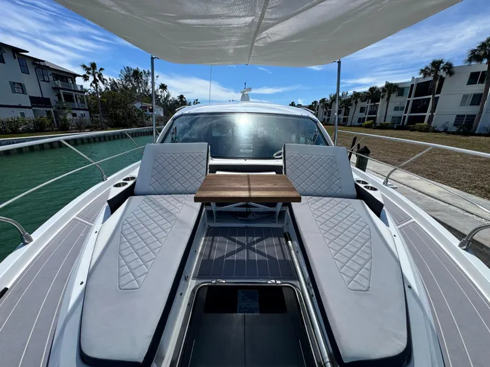 Truly Ineffable Yacht Photos Pics 2019 Cruisers Yachts 42 Cantius with sun loungers and table on deck, docked by waterfront homes.
