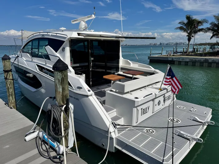 Truly Ineffable Yacht Photos Pics 2019 Cruisers Yachts 42 Cantius docked, featuring sleek design and spacious deck area.