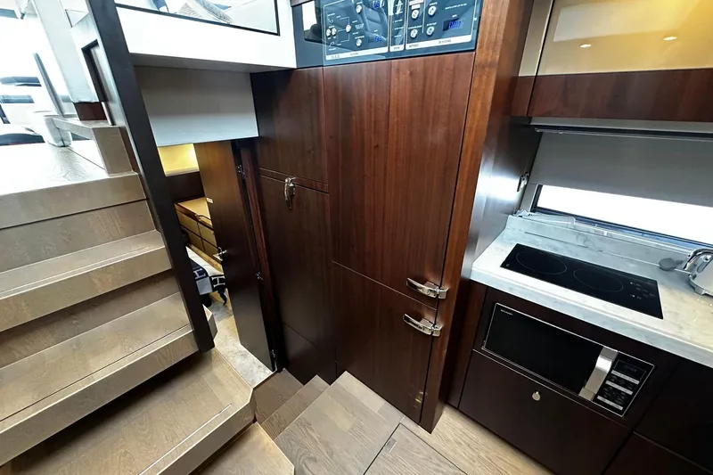  Yacht Photos Pics Interior of 2023 Fairline Squadron 50 yacht, featuring modern kitchen and wooden stairs.