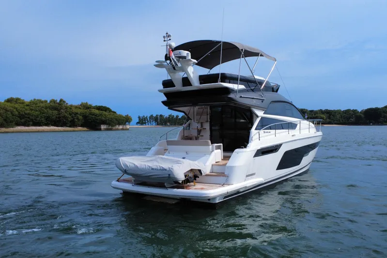  Yacht Photos Pics 2023 Fairline Squadron 50 yacht cruising on serene waters near lush island.