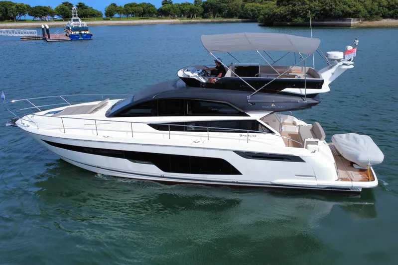  Yacht Photos Pics 2023 Fairline Squadron 50 yacht cruising on a serene lake with lush greenery.