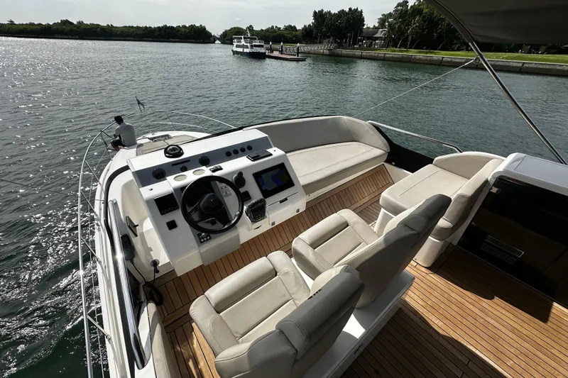  Yacht Photos Pics 2023 Fairline Squadron 50 yacht cockpit with luxurious seating and modern controls on a sunny day.