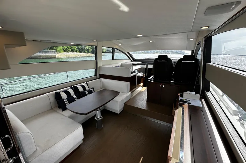 Yacht Photos Pics Luxurious interior of 2023 Fairline Squadron 50 yacht with elegant seating and panoramic windows.