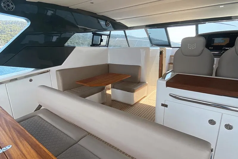  Yacht Photos Pics Luxurious interior of 2025 Makai M37 yacht with modern seating and wooden table.