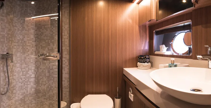  Yacht Photos Pics Luxurious bathroom in 2021 Greenline OceanClass 68 yacht with modern fixtures and wood paneling.