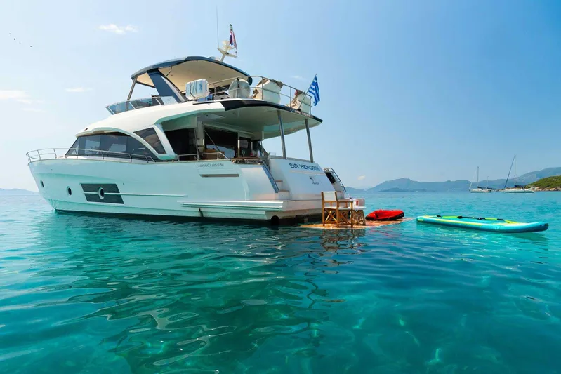  Yacht Photos Pics 2021 Greenline OceanClass 68 yacht anchored with paddleboards in clear blue water.