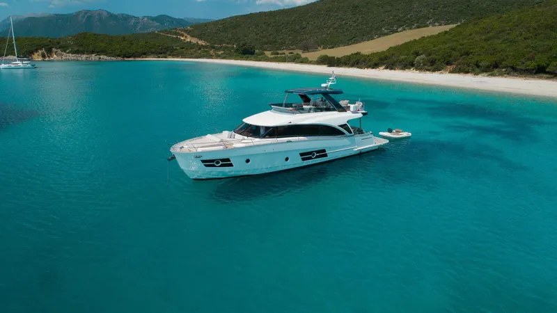  Yacht Photos Pics Luxury Greenline OceanClass 68 yacht anchored in turquoise waters near a scenic beach, 2021 model.