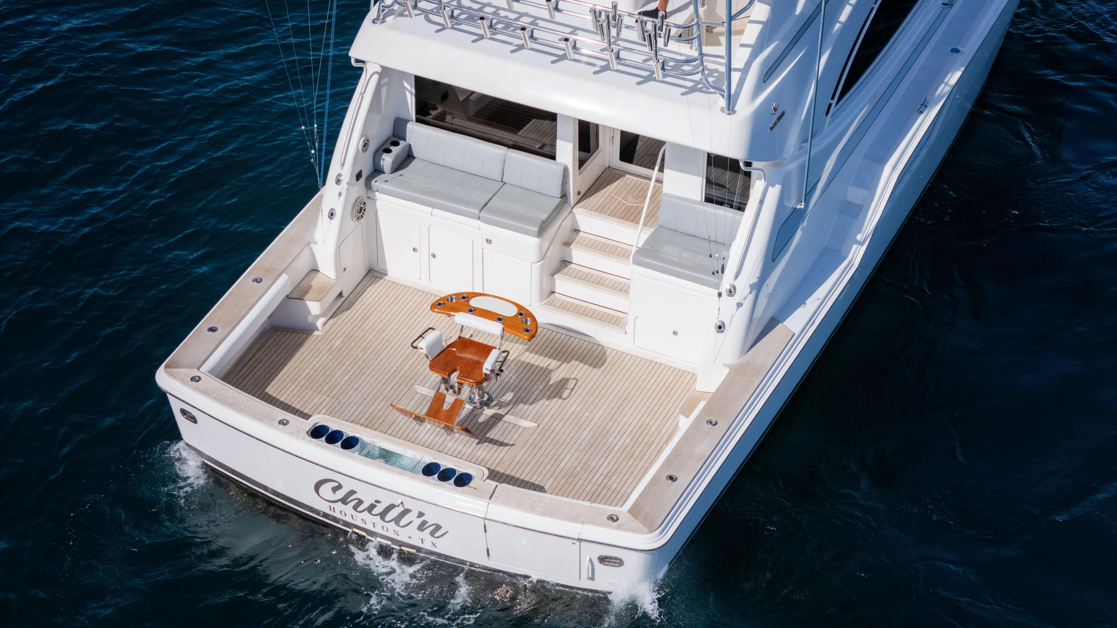 Chill 'n Yacht Photos Pics 2003 Bertram 67 Convertible yacht on water, rear view with fishing chair.