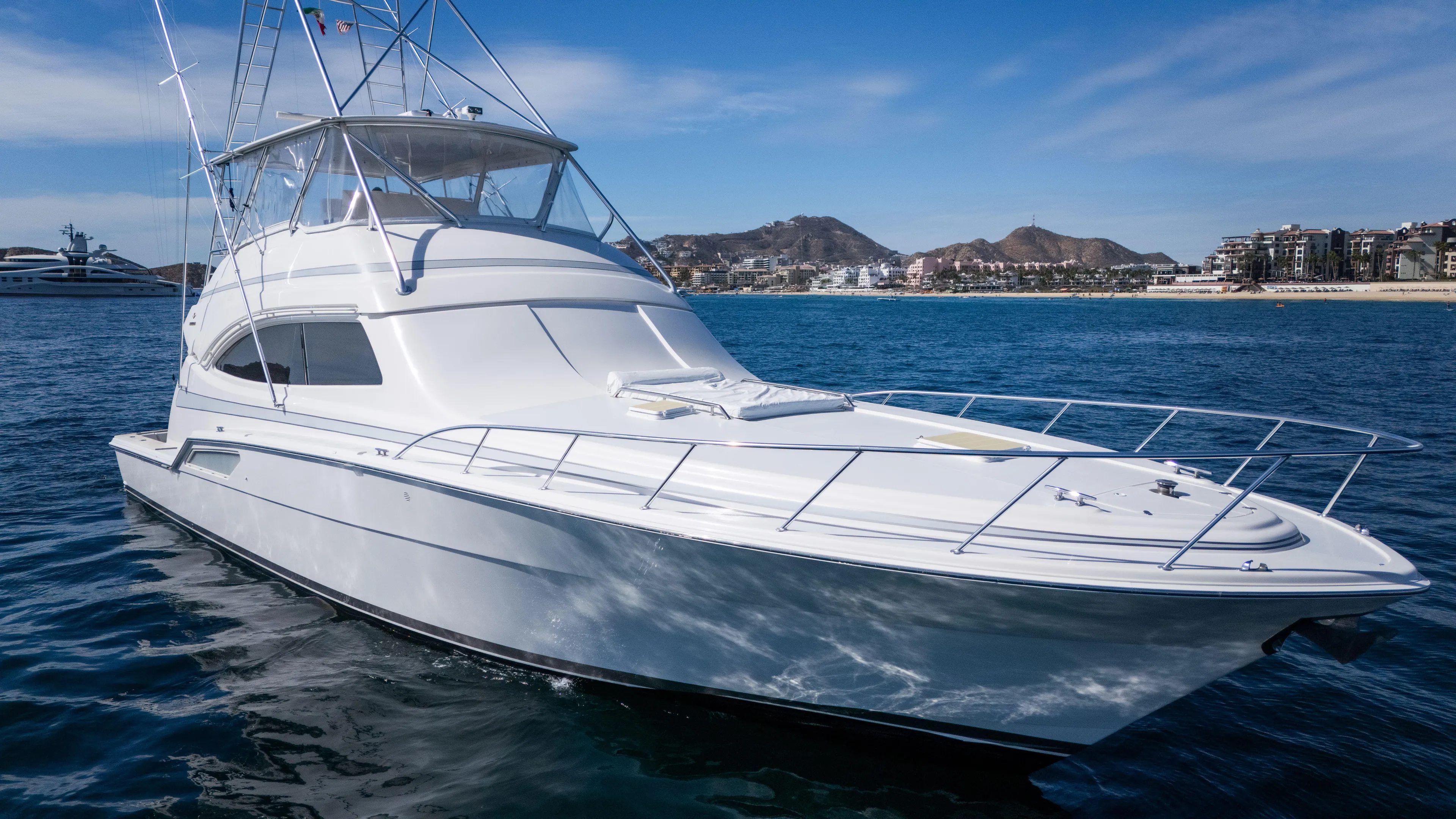 Chill 'n Yacht Photos Pics 2003 Bertram 67 Convertible yacht on calm ocean with coastal background.