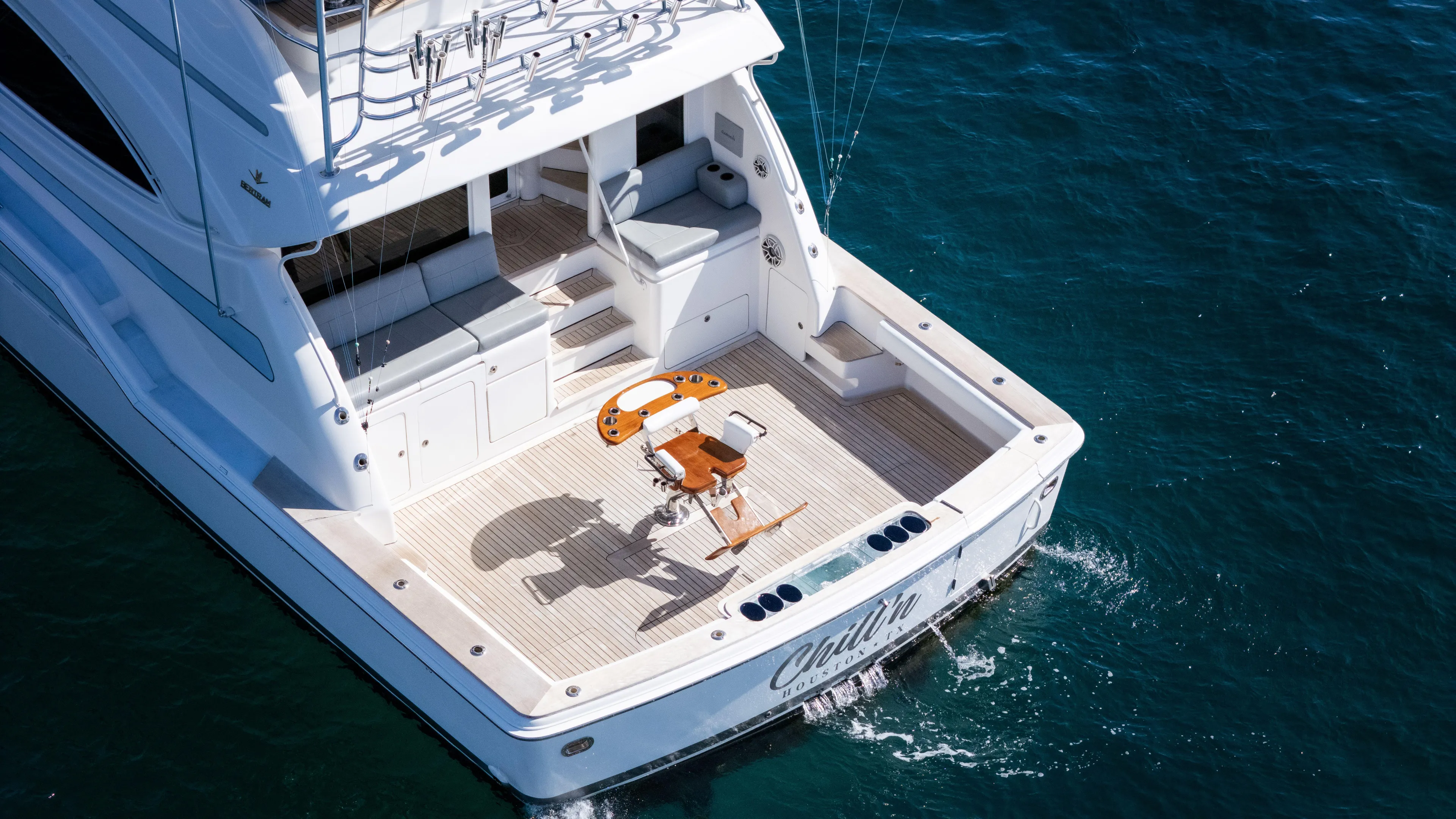 Chill 'n Yacht Photos Pics 2003 Bertram 67 Convertible yacht on water, featuring spacious deck and seating area.