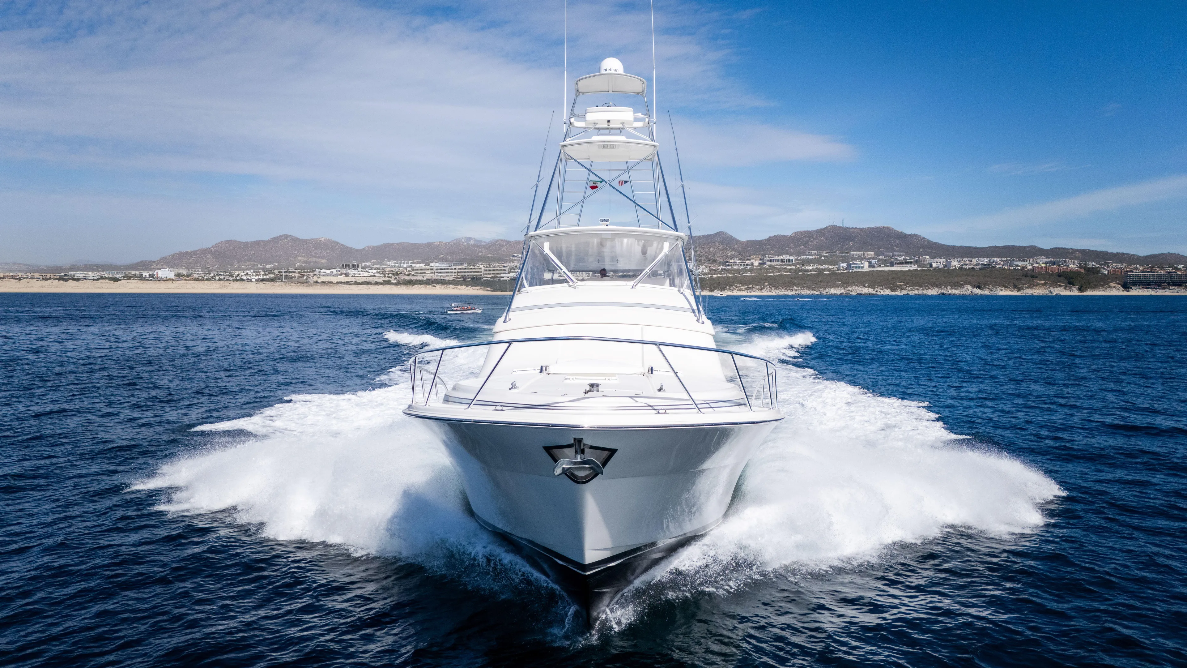 Chill 'n Yacht Photos Pics 2003 Bertram 67 Convertible yacht cruising on open water, with scenic coastline in background.