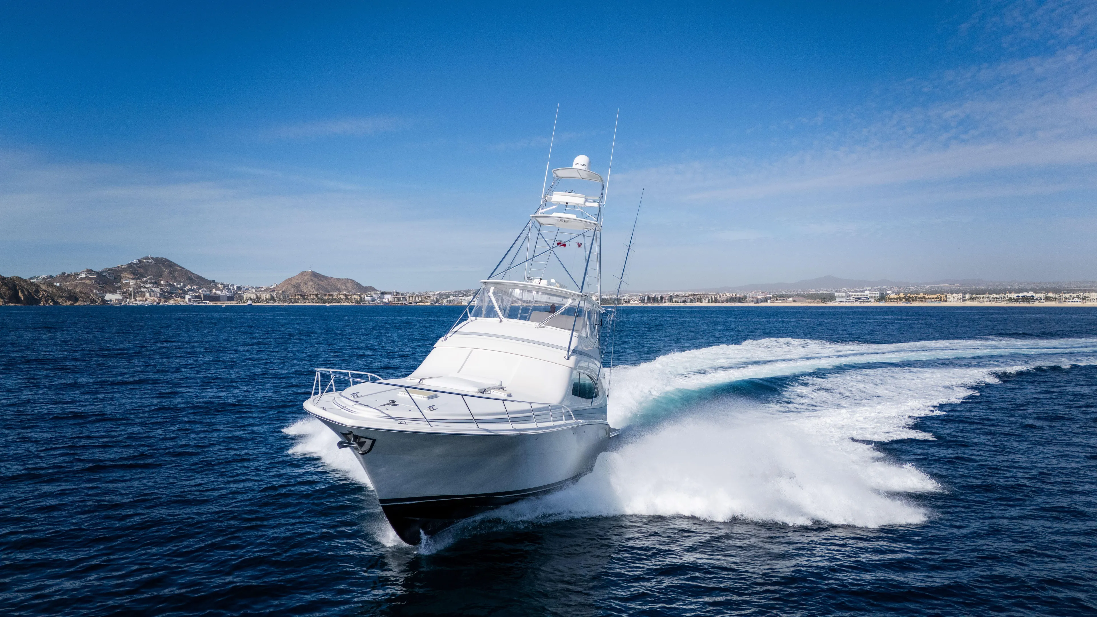 Chill 'n Yacht Photos Pics 2003 Bertram 67 Convertible yacht cruising on open water, with scenic coastal backdrop.