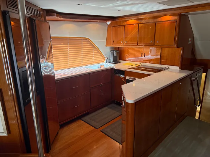 Chill 'n Yacht Photos Pics Luxurious kitchen interior of a 2003 Bertram 67 Convertible yacht with wooden cabinetry.