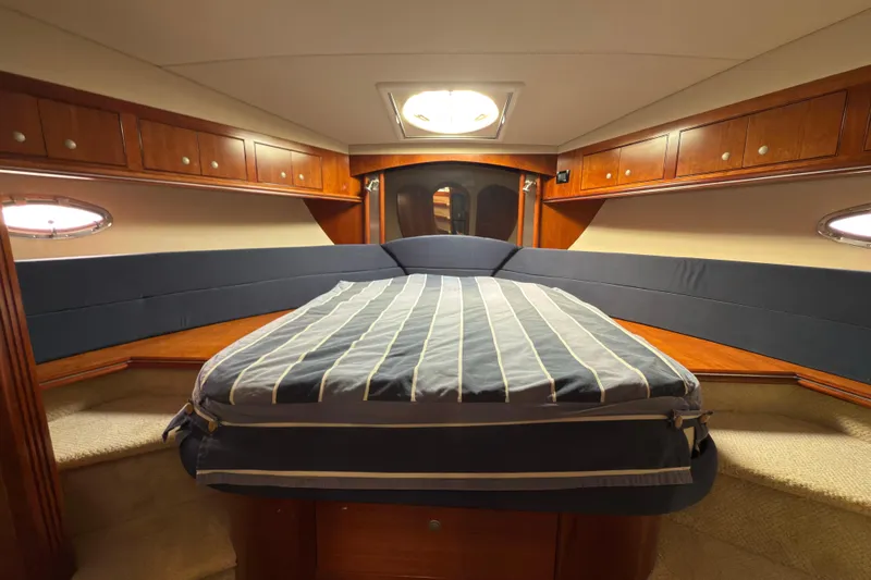  Yacht Photos Pics Luxurious 2008 Cruisers 455 Motor Yacht bedroom with elegant wood cabinetry and cozy bedding.