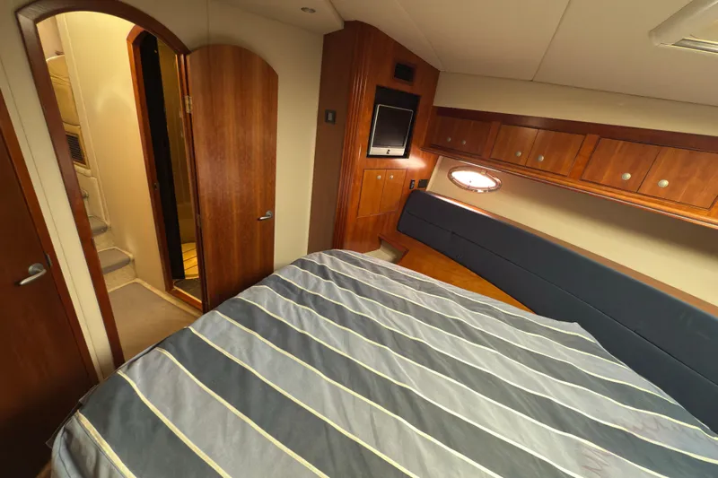  Yacht Photos Pics Luxurious 2008 Cruisers 455 Motor Yacht bedroom with wood accents and striped bedding.