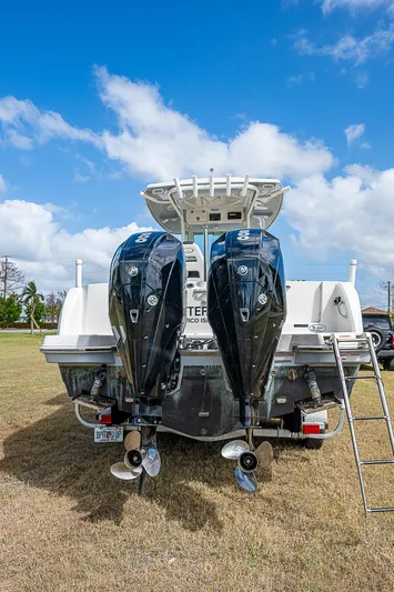  Yacht Photos Pics 2022 Sailfish 272CC boat with dual outboard motors on grassy field.