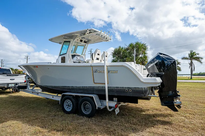  Yacht Photos Pics 2022 Sailfish 272CC boat on trailer, parked on grass under a partly cloudy sky.