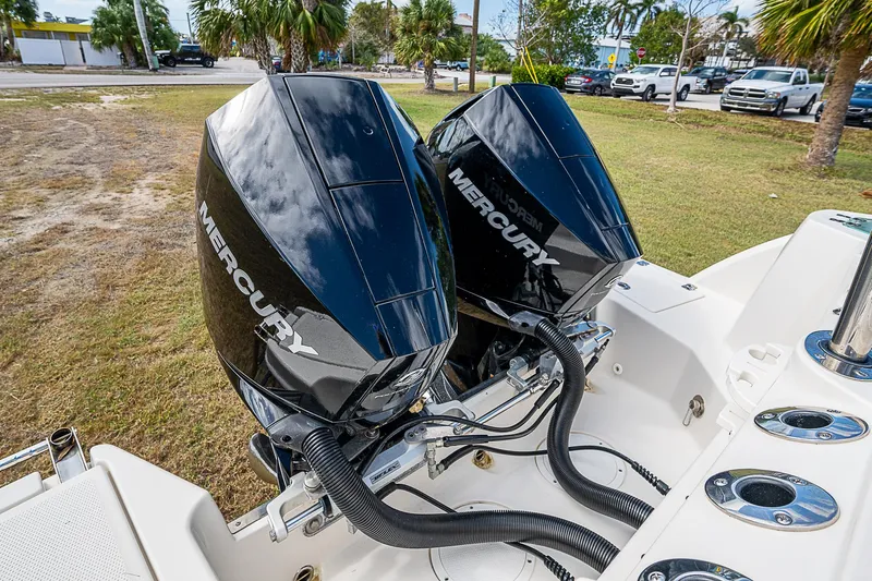  Yacht Photos Pics Twin Mercury outboard engines on a 2022 Sailfish 272CC boat, parked on grass.