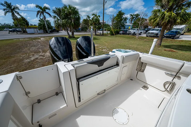  Yacht Photos Pics 2022 Sailfish 272CC boat interior with dual outboard motors, parked near palm trees.