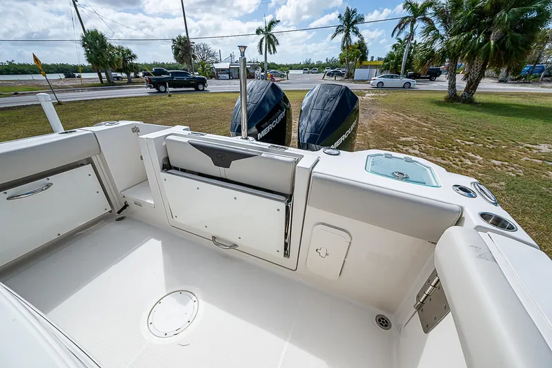  Yacht Photos Pics 2022 Sailfish 272CC boat interior with twin outboard motors, parked near a road.