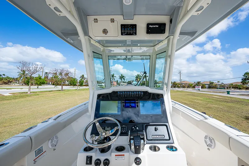 Yacht Photos Pics 2022 Sailfish 272CC boat cockpit with modern navigation system and steering wheel.
