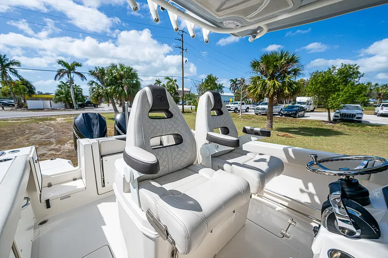  Yacht Photos Pics 2022 Sailfish 272CC boat interior with plush seating and steering wheel.
