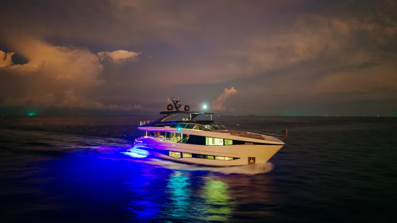  Yacht Photos Pics Luxurious 2023 Princess Y95 yacht illuminated on the ocean at night.