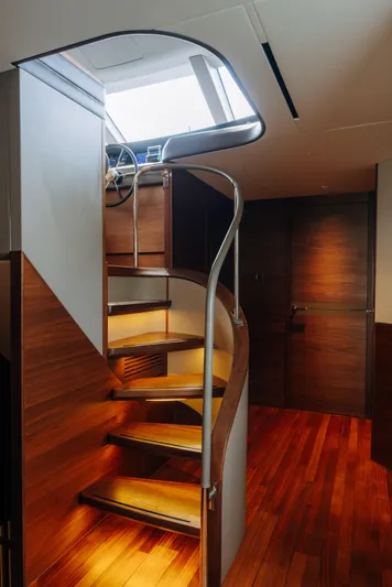  Yacht Photos Pics Spiral staircase in 2023 Princess Y95 yacht with wooden interior and modern design.