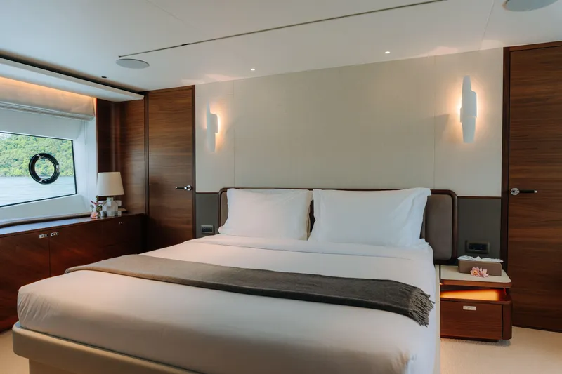  Yacht Photos Pics Luxurious bedroom interior on 2023 Princess Y95 yacht, featuring elegant wood finishes and modern lighting.