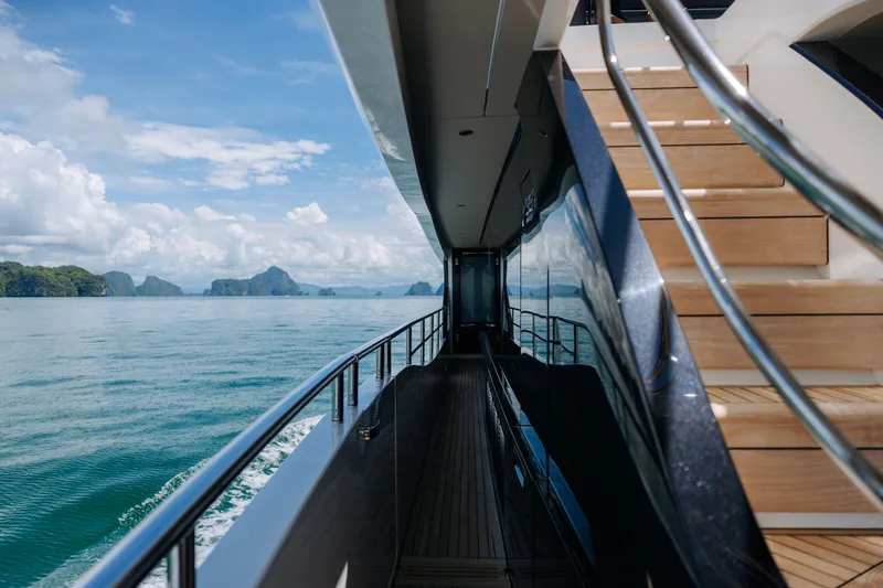  Yacht Photos Pics Luxurious 2023 Princess Y95 yacht deck with ocean view and wooden stairs.